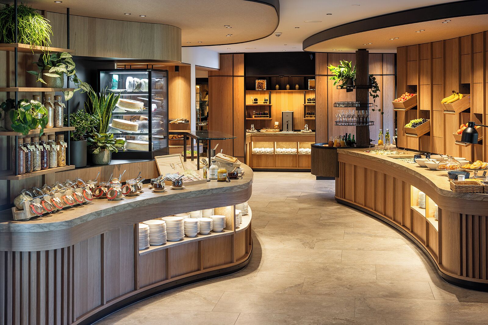 A modern breakfast bar with a curved design, featuring a variety of food items and condiments.