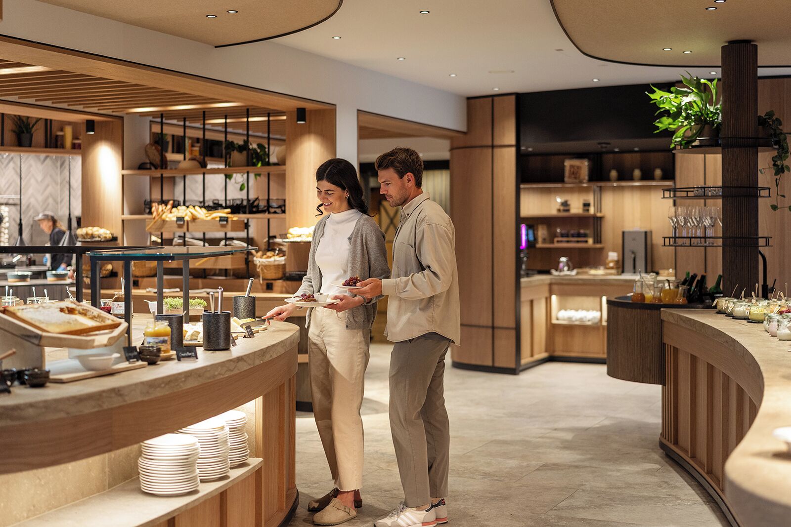 A modern café interior with a counter, seating area, and various food items.