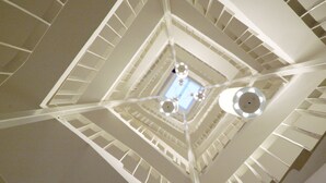 A multi-level interior with a central open space and multiple floors connected by staircases. - Alma Boutique Hotel (Vienna)