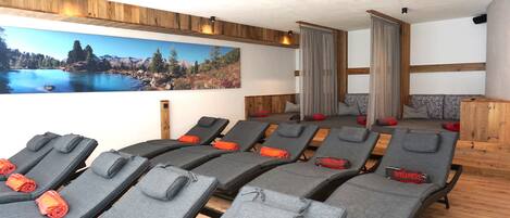 A wellness room with multiple massage chairs, a large scenic wall mural, and wooden paneling.