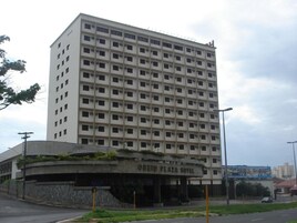 A multi-story hotel with a uniform facade, numerous windows, and a sign indicating it is the Obied Plaza Hotel.