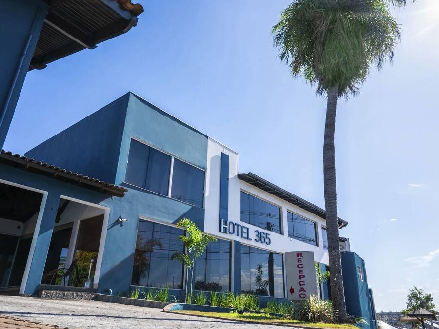 Un hotel moderno con facciata blu, ampie finestre e un cartello con la scritta 'HOTEL 365'.
