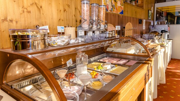Un bufé con diversos alimentos y un dispensador de leche.