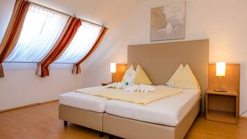 Een hotelkamer met een bed, twee bedlampen, een raam met gordijnen en een kunstwerk aan de muur.