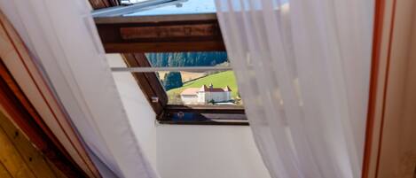 A window with a view of a house and a package of Soletti chocolate.