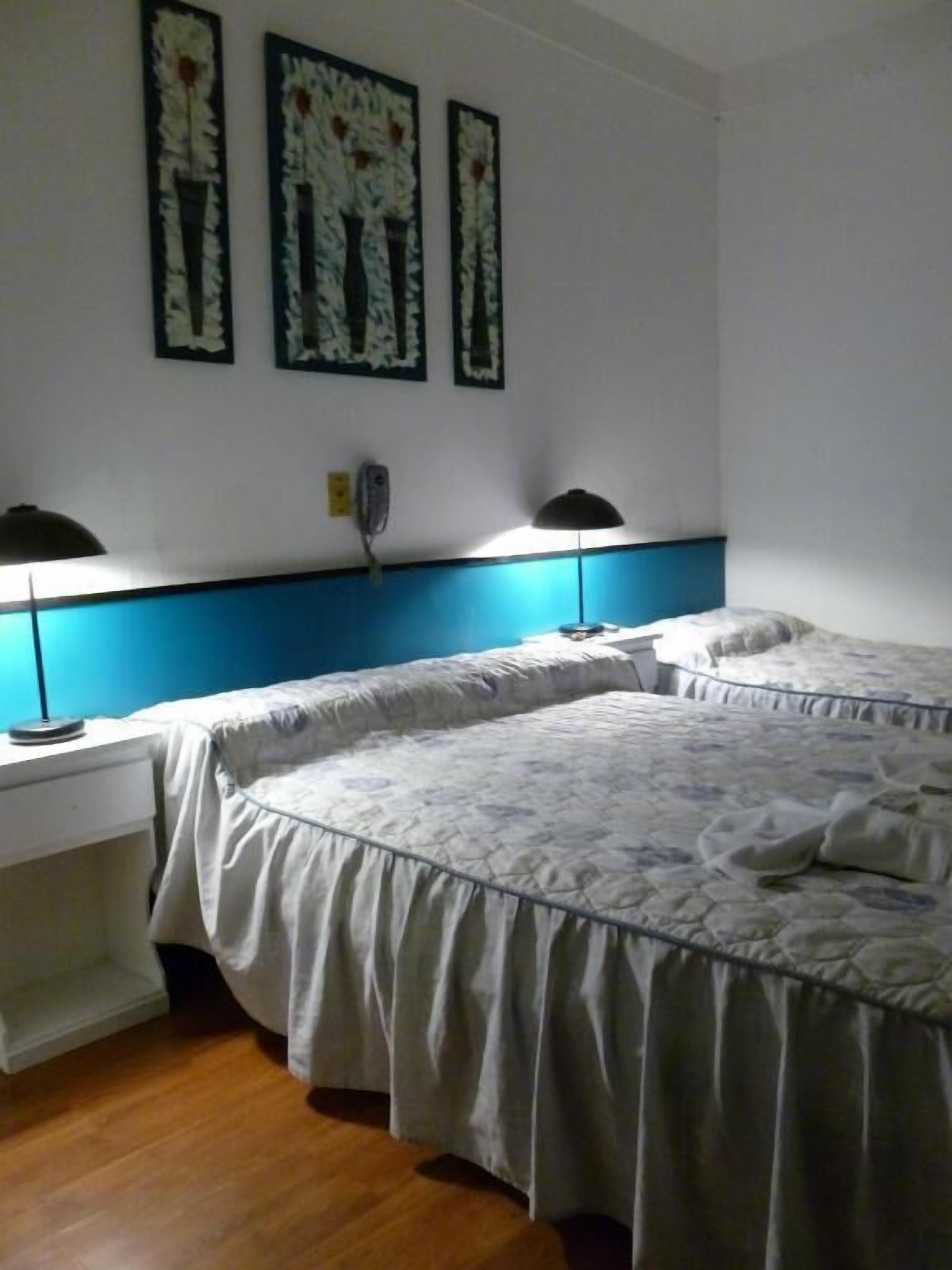 A room with two beds, a desk, and a telephone.