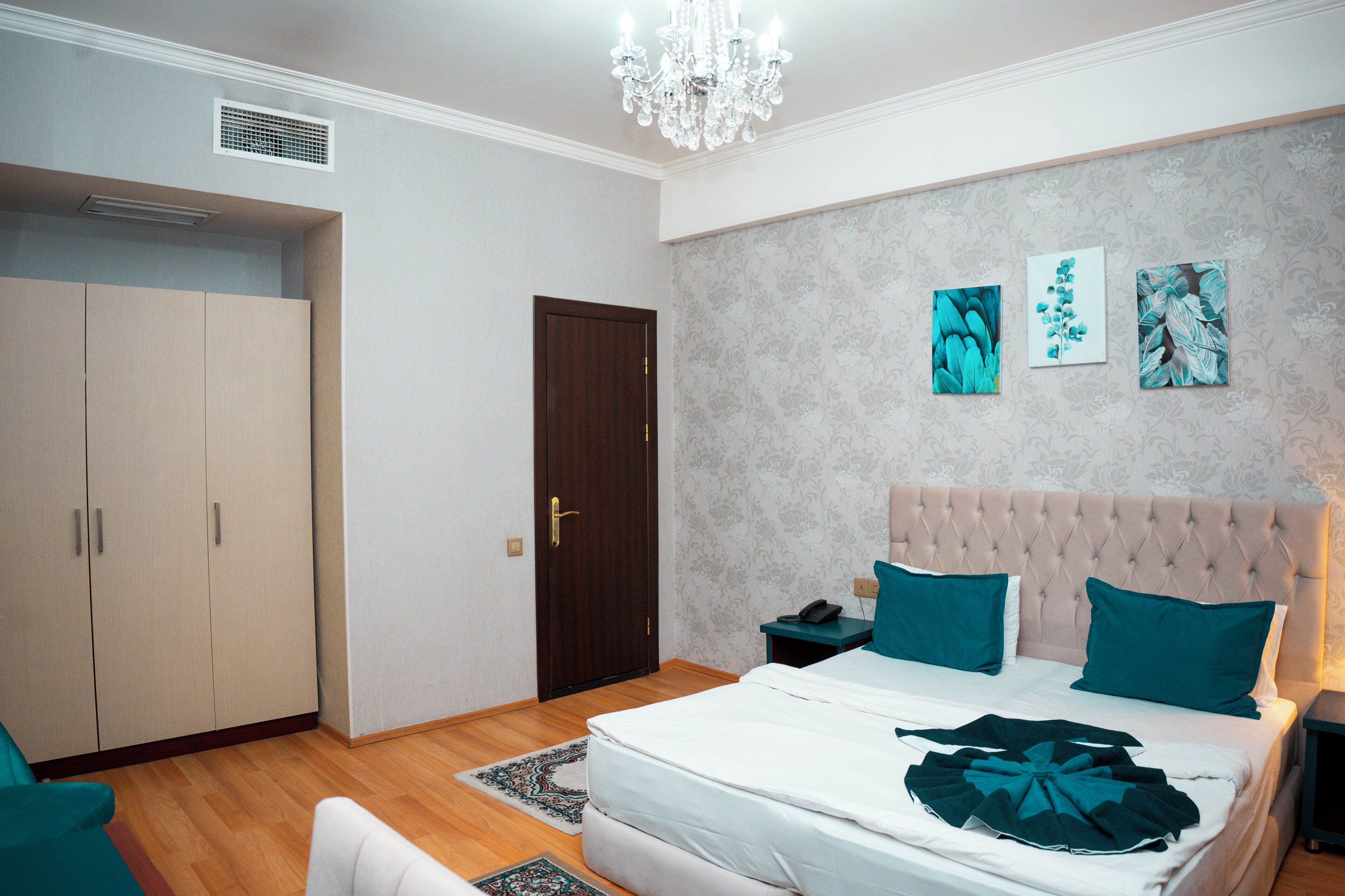 Un dormitorio con cama, mesitas de noche, cómoda y una puerta.