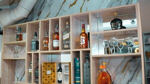 Un mobile bar con diverse bottiglie e bicchieri.