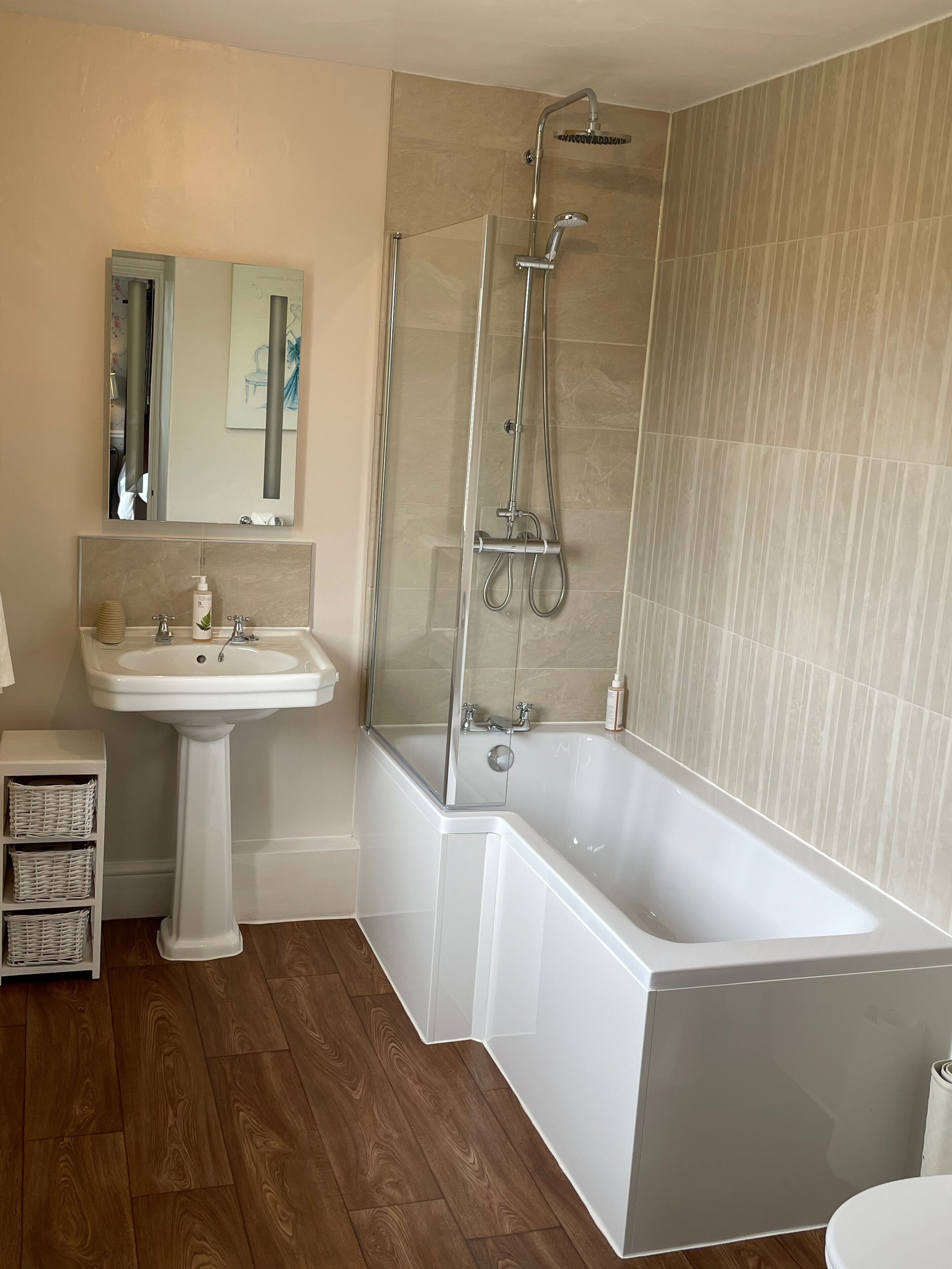 Un baño moderno con una bañera independiente, un lavabo sobre pedestal y una ducha con mampara de vidrio.