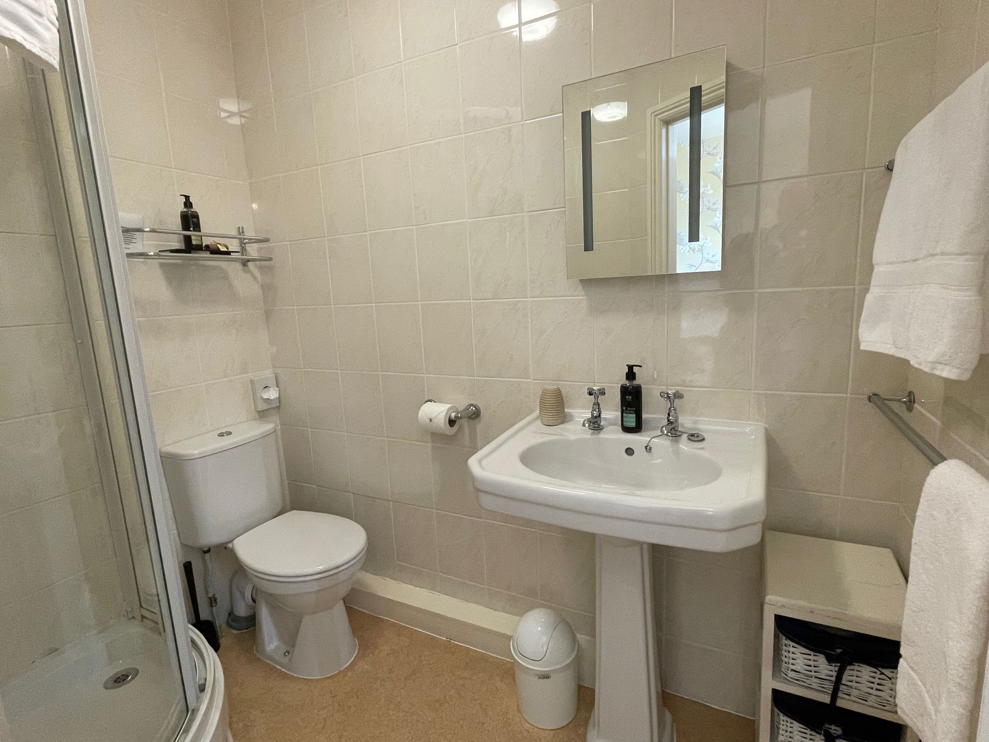 A bathroom with a toilet, sink, and shower.