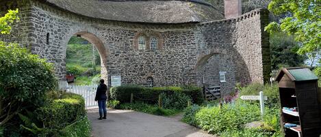 A stone archway leading to a building with a sign indicating toll charges.