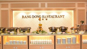A buffet setup at Rang Dong Restaurant with various food containers and dishes. - Rang Dong Hotel (Ho Chi Minh City)