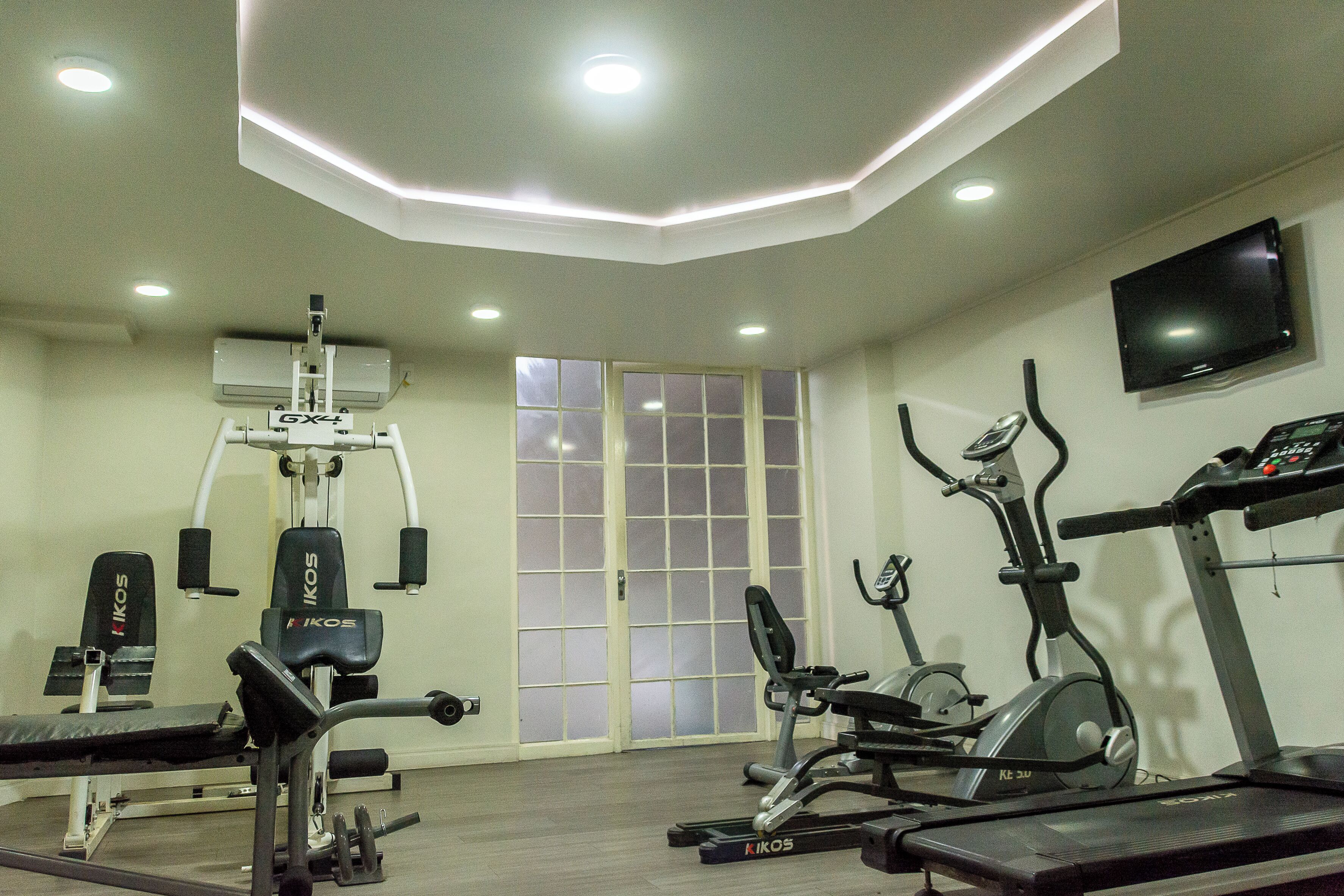 A gym with various exercise equipment, including treadmills, an elliptical, and weight machines.