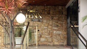El exterior del Hotel Fenix, con fachada de piedra, entrada de cristal y una escalera que lleva a la entrada.