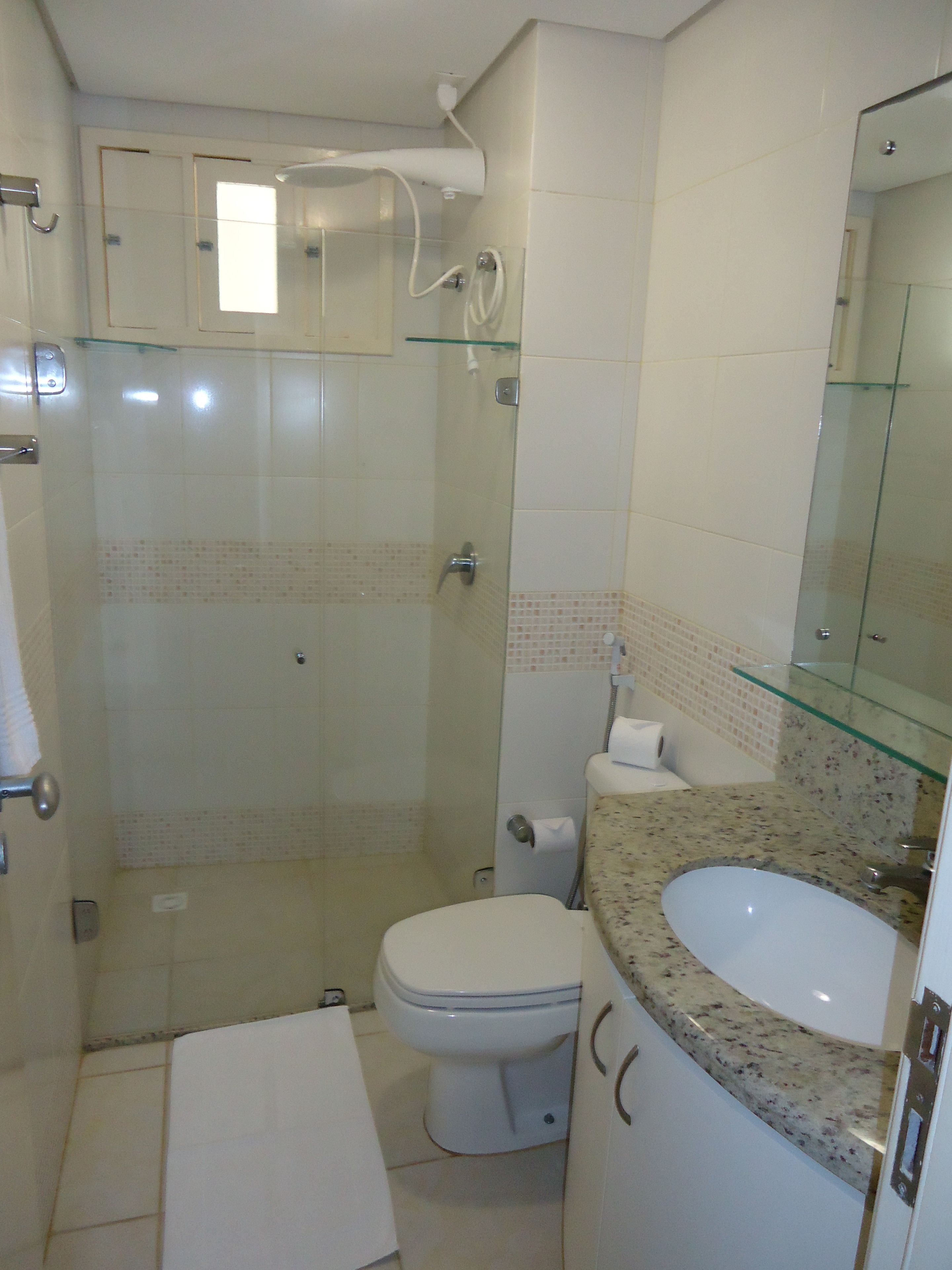 Ein Badezimmer mit Duschkabine, Toilette und Waschbecken mit Marmorplatte.