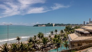 A coastal view with a beach, palm trees, and a swimming pool. - Apart Hotel Vespucci Residence (Natal)