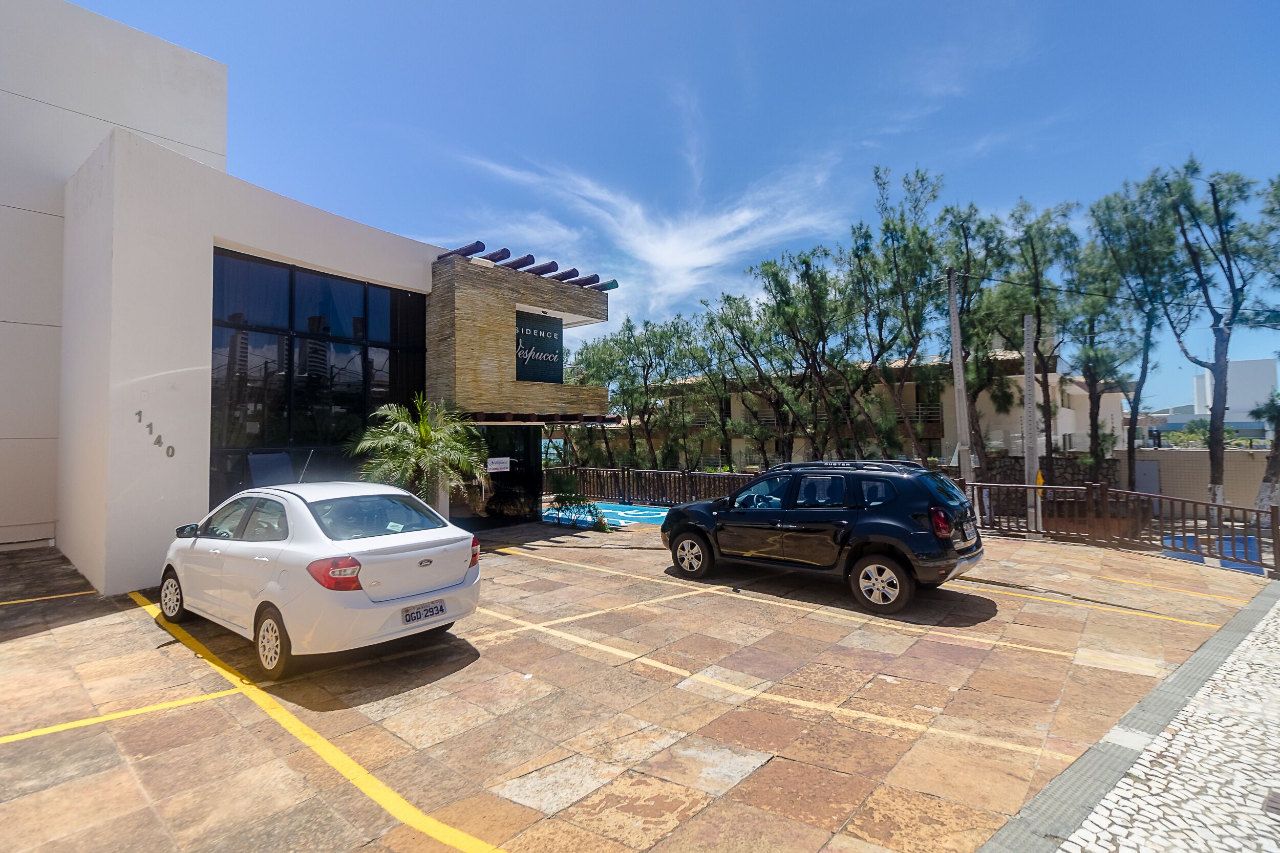Um edifício moderno com uma fachada de vidro extensa e uma placa com a inscrição 