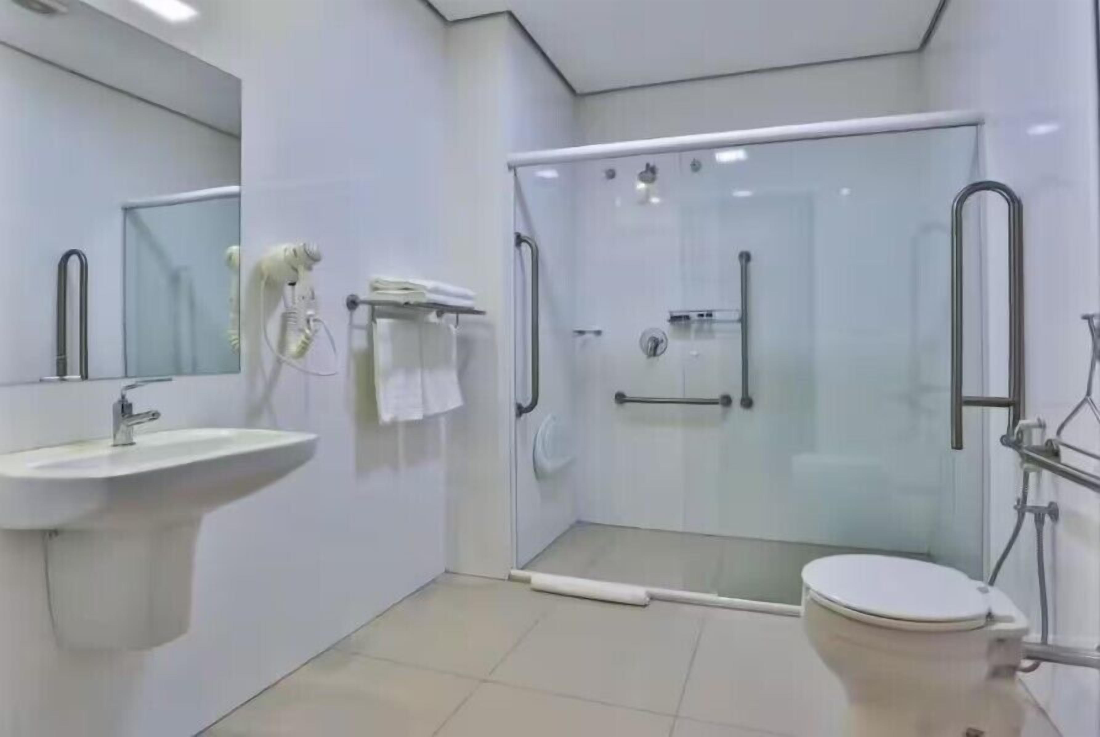 A modern bathroom with a glass shower enclosure, a sink, and a toilet.