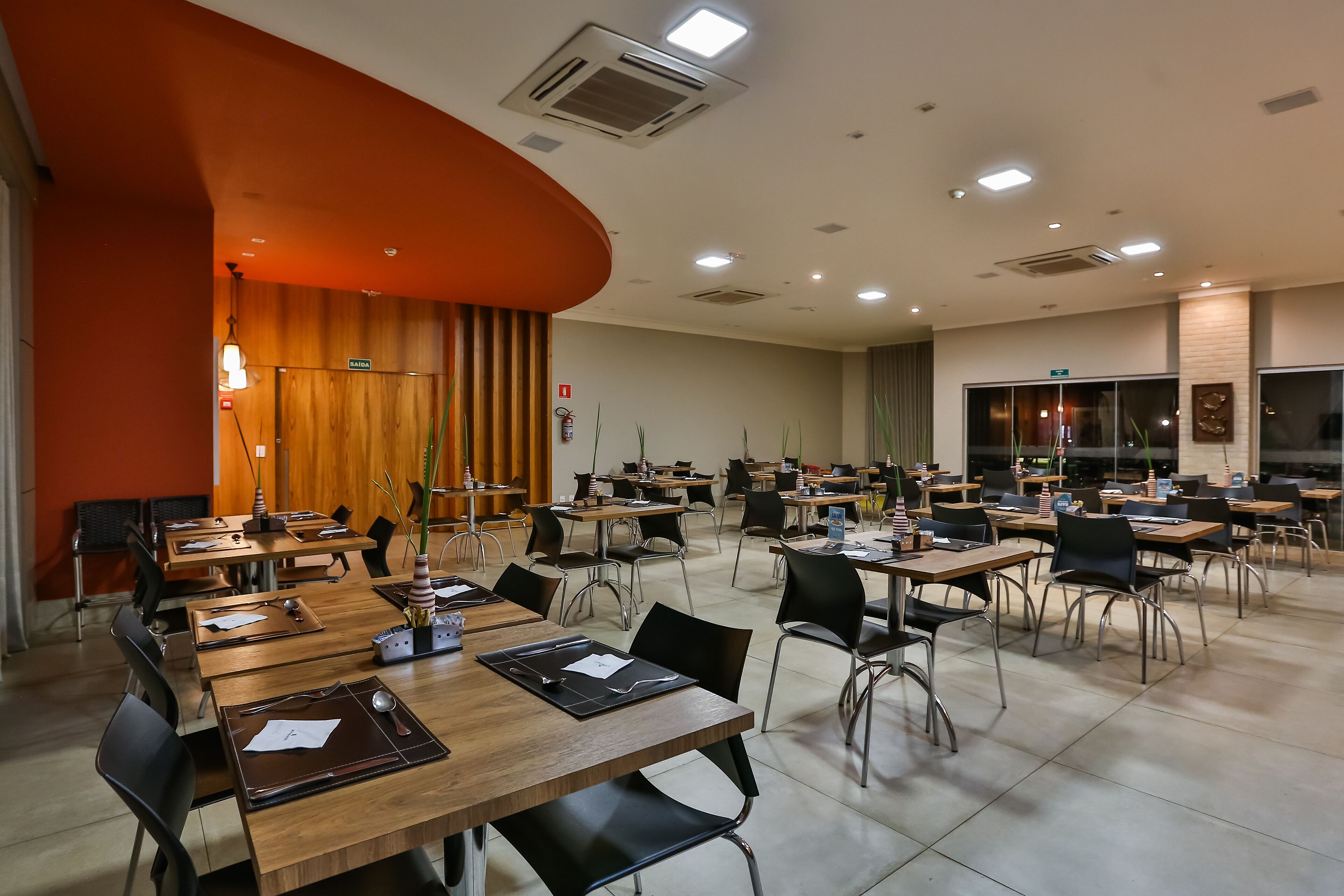 A conference room with multiple tables and chairs, equipped with nameplates and notepads.
