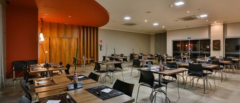 A conference room with multiple tables and chairs, equipped with nameplates and notepads.