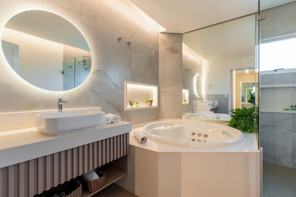 A modern bathroom with a large oval mirror, a freestanding bathtub, and a vessel sink. - Ucayali Hotel (Sinop)