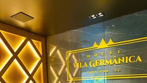 Ein modernes Hotelinnere mit einem gut sichtbaren Schild mit der Aufschrift 'HOTEL VILA GERMÂNICA PIRATUBA SC'.