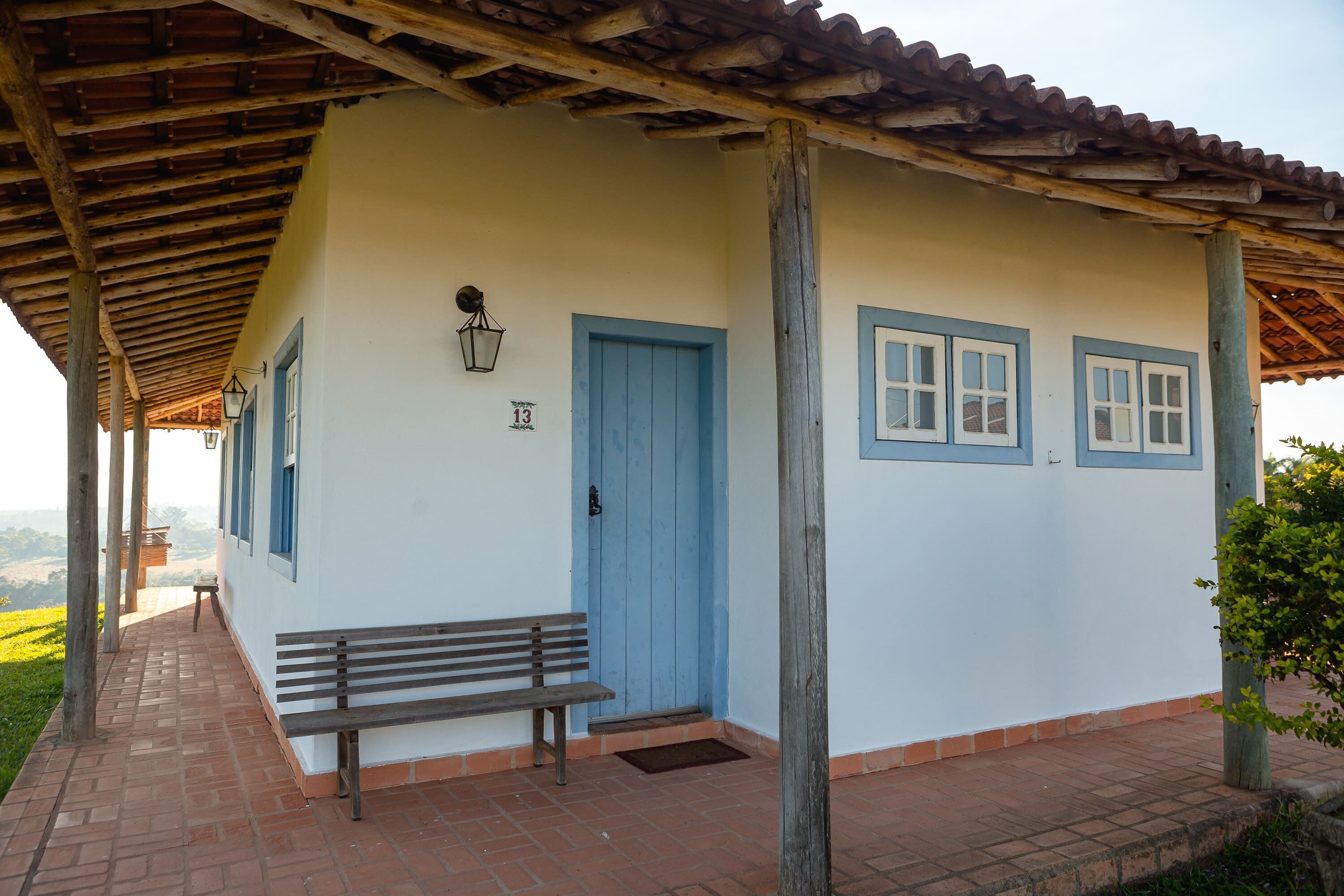 A building with a blue door, a bench, and a number 13 sign.
