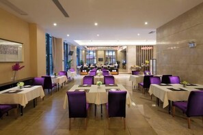 A hotel dining area with multiple tables and chairs, arranged in rows, with a view of the dining area in the background. - Bayview Hotel (Dongguan Guomao Center Xiping West Station) (Dongguan)