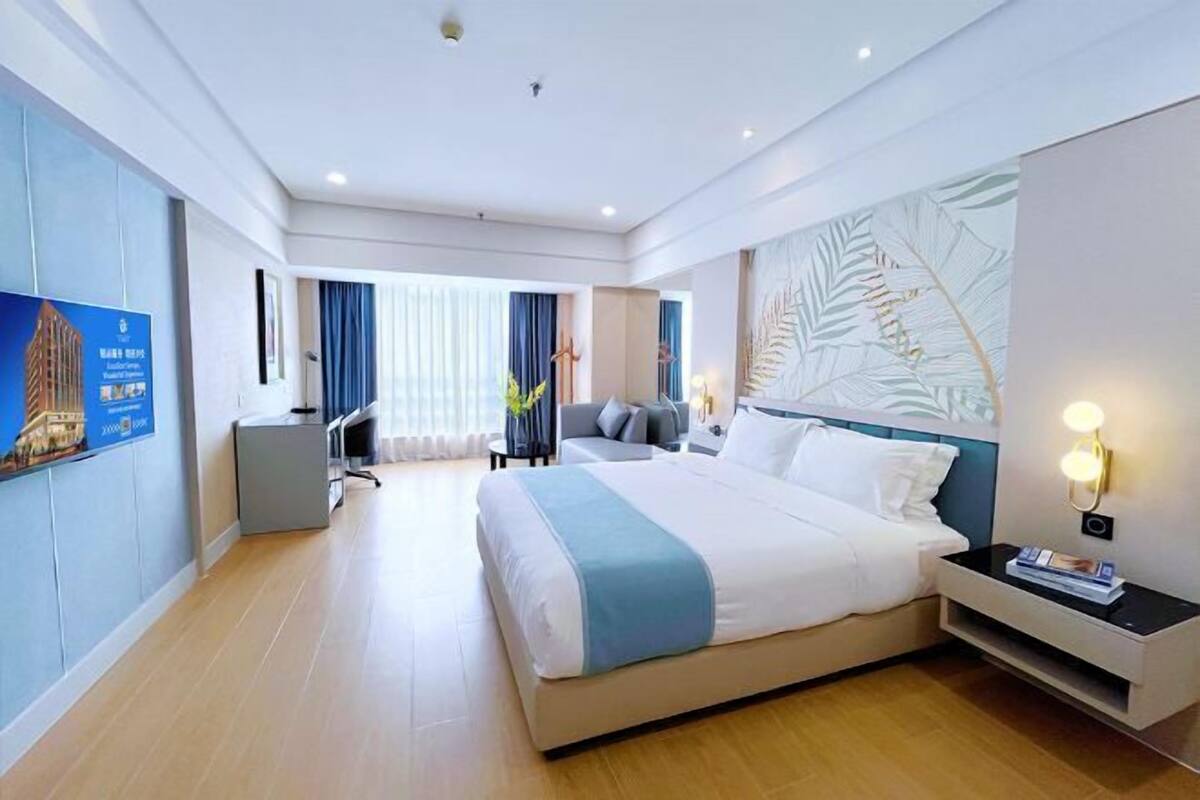 Une chambre d’hôtel moderne dotée d’un grand lit, d’un bureau et d’un coin salon.