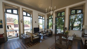Amplia sala de estar con televisor grande, asientos cómodos y ventanas grandes con vistas al exterior.