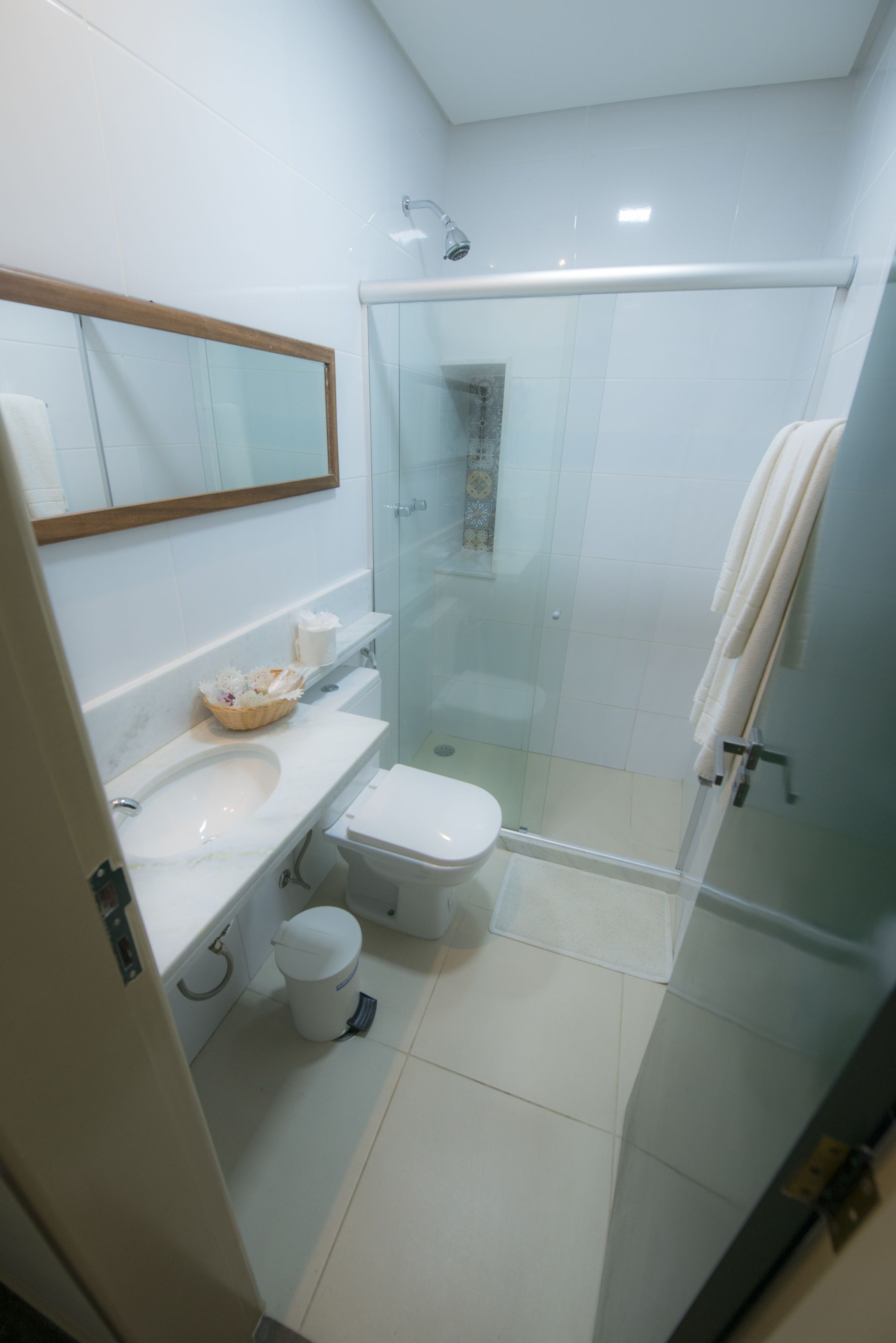 Une salle de bain moderne avec une douche à parois de verre, un lavabo blanc et des toilettes.