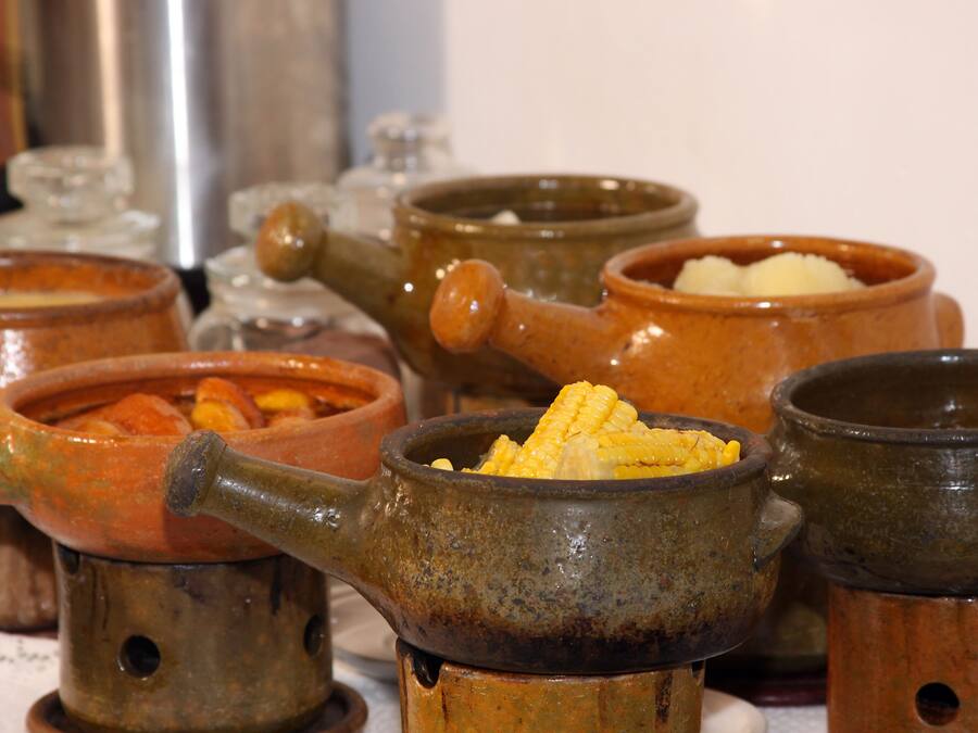 Un conjunto de ollas y utensilios rústicos, probablemente utilizados para métodos de cocina tradicionales.
