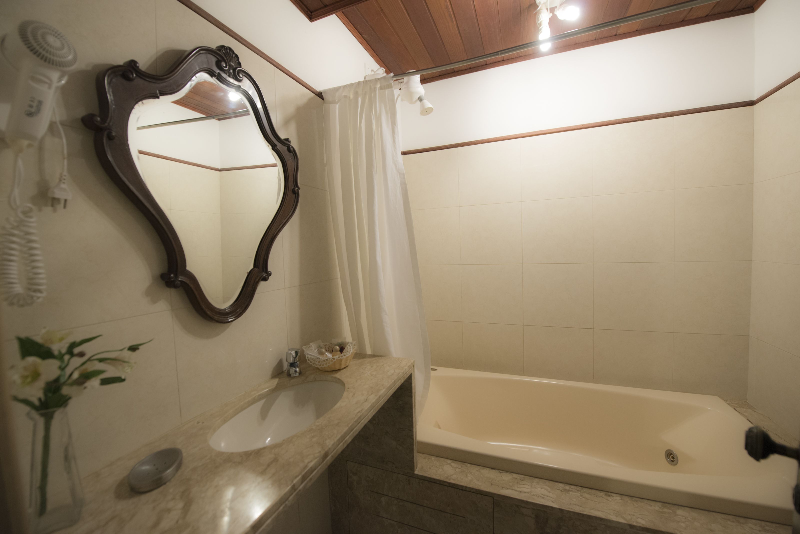 Une salle de bain équipée d’un meuble-lavabo, d’un évier, d’un miroir et d’une baignoire.