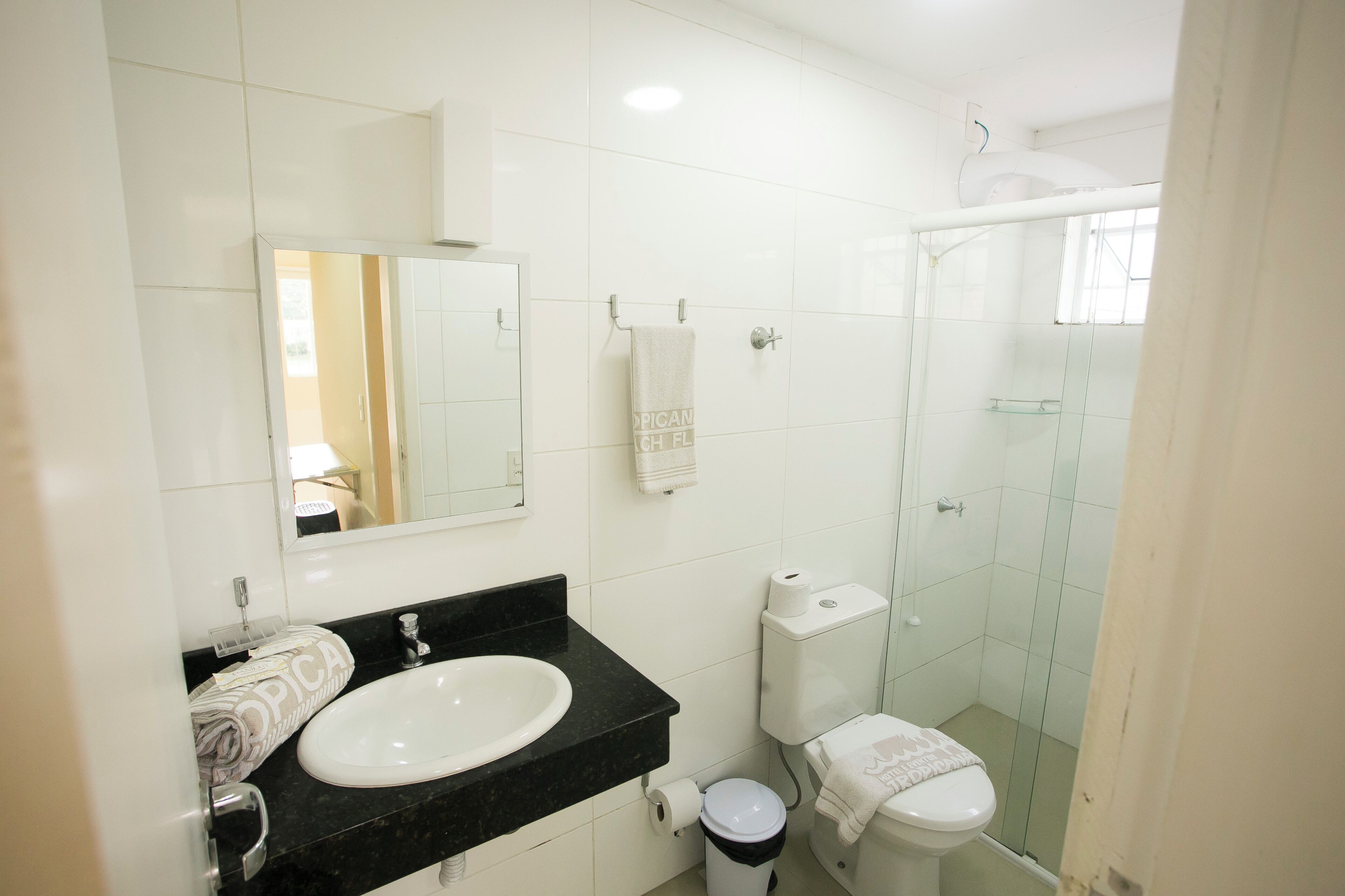 A bathroom with a sink, toilet, and glass shower enclosure.