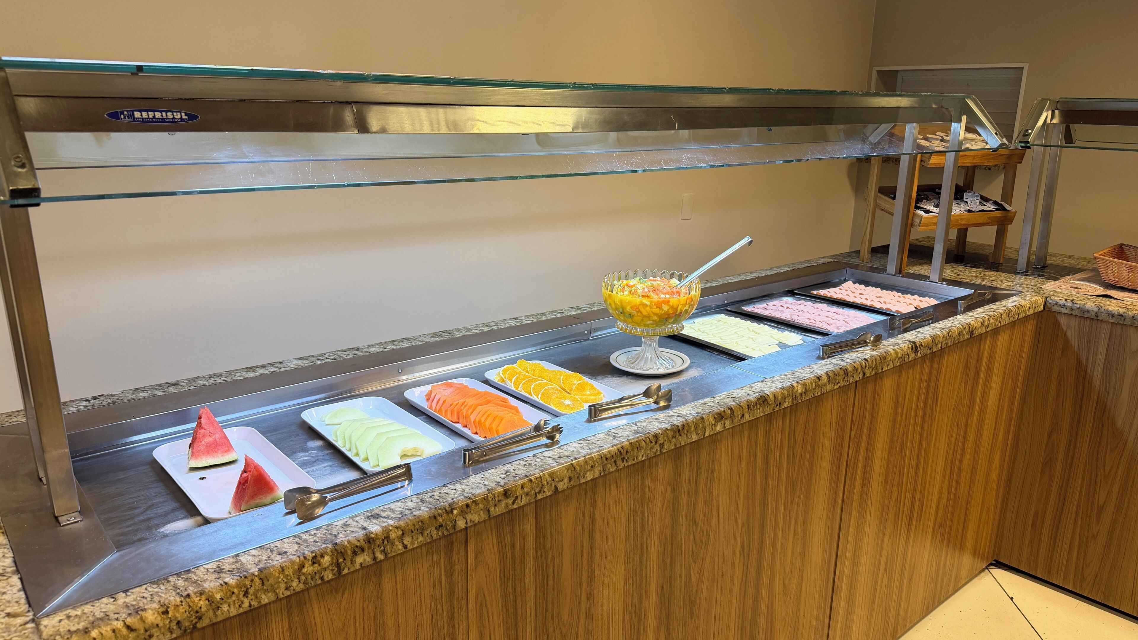A buffet with various food items and a fruit bowl.