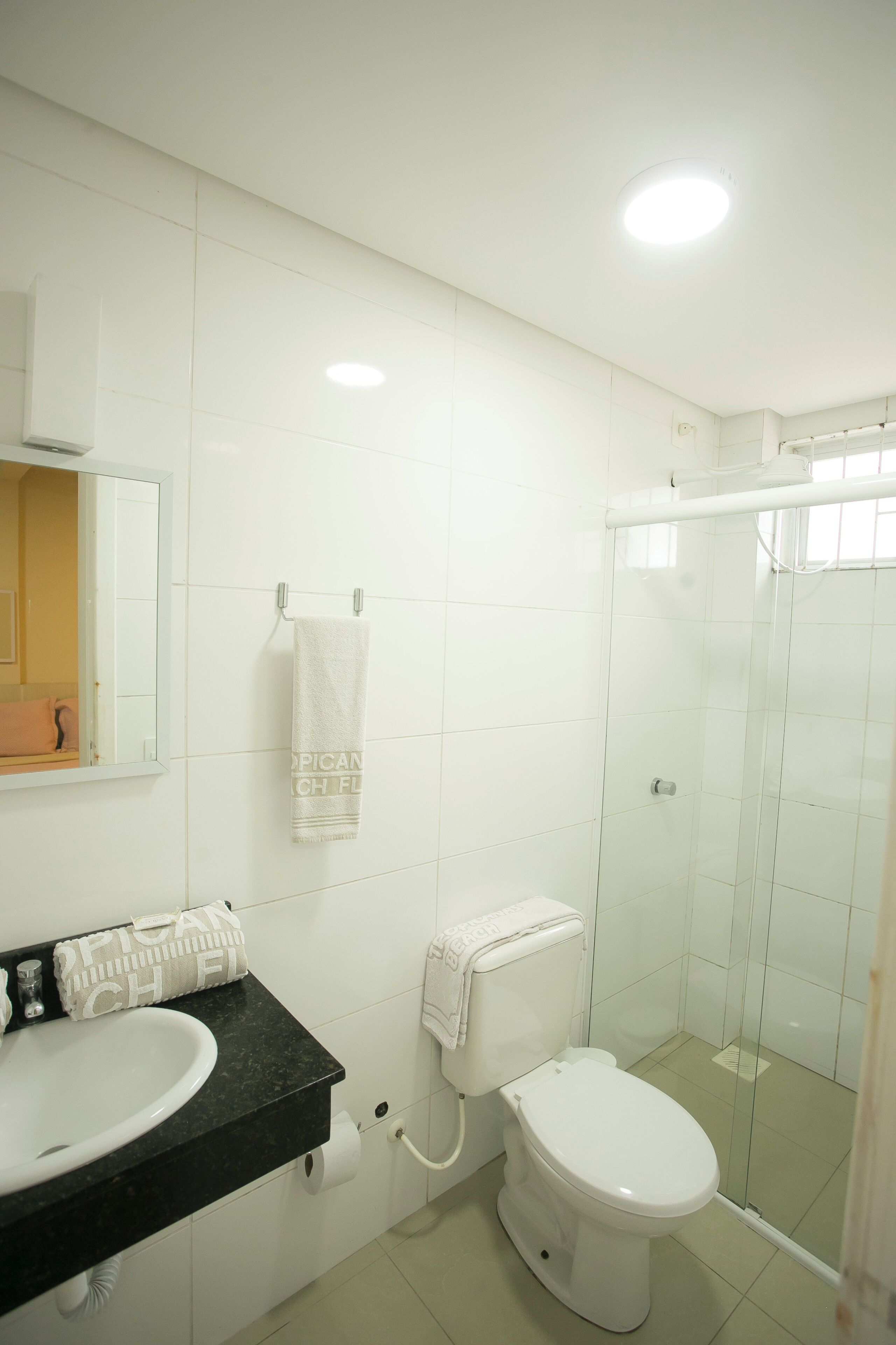 Un baño con lavamanos, inodoro y ducha blancos.