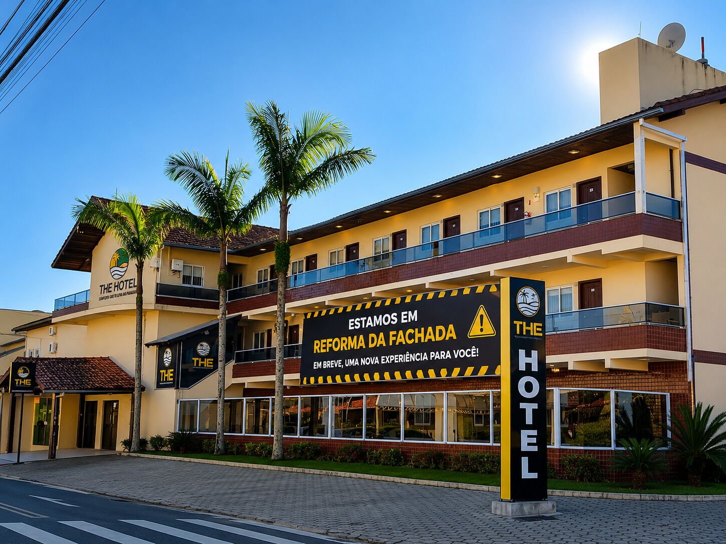 A hotel with a sign indicating renovation, multiple balconies, and palm trees.