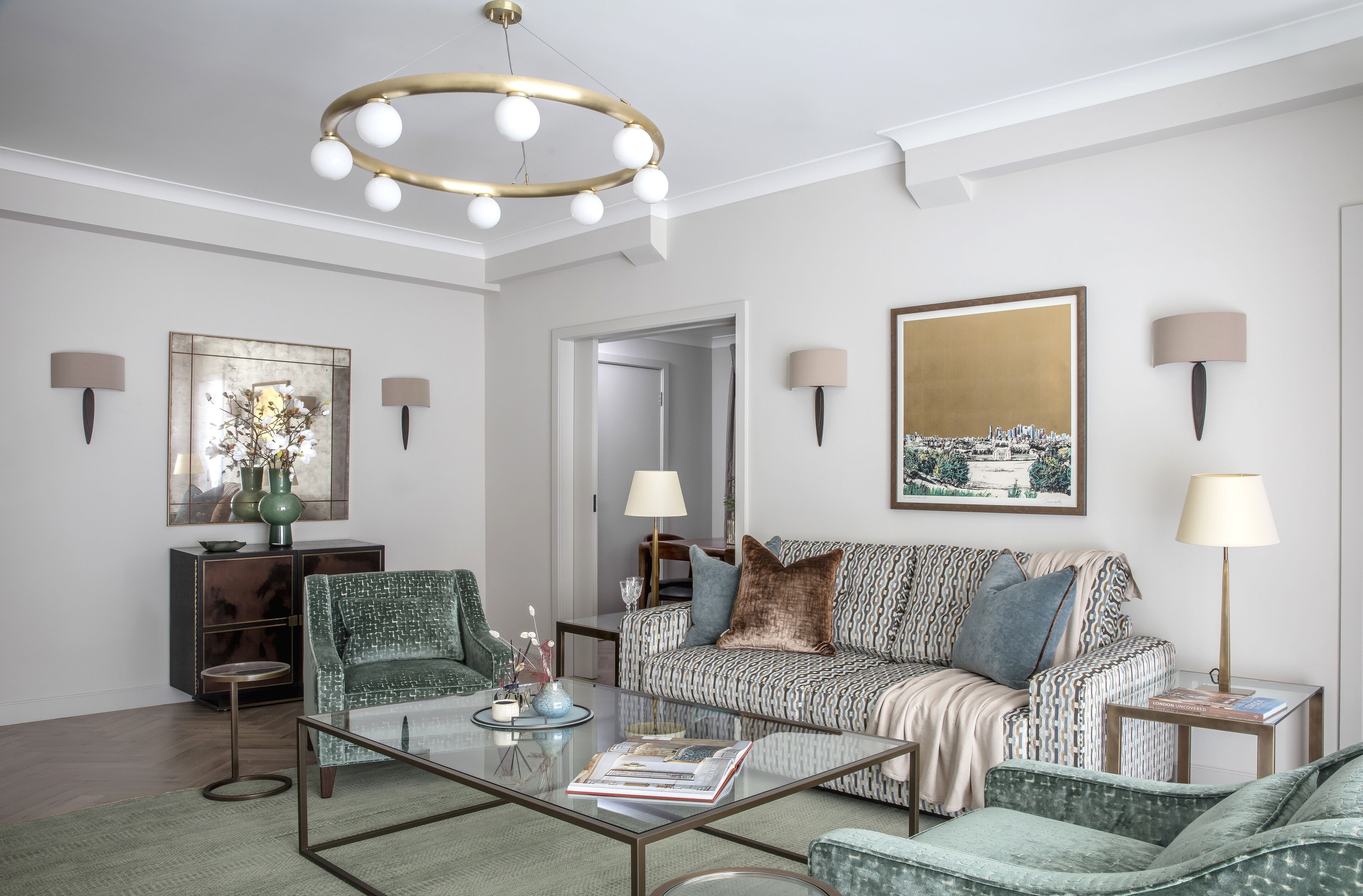 A modern living room with a sofa, armchairs, a coffee table, and a chandelier.