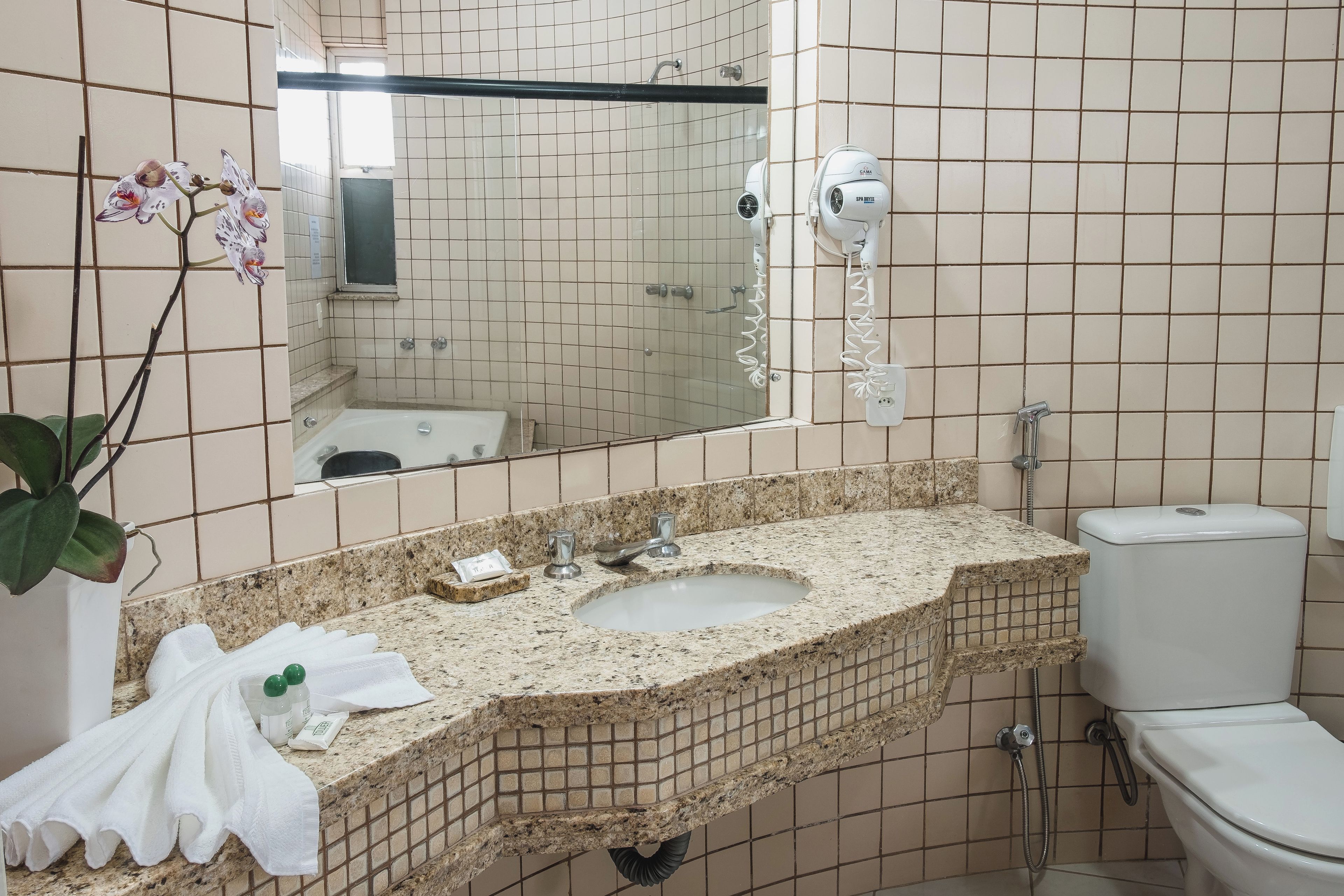 Un baño con lavamanos, espejo e inodoro.