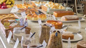 Un buffet proposant une variété de pains, de viennoiseries et de pots de confitures et de pâtes à tartiner.