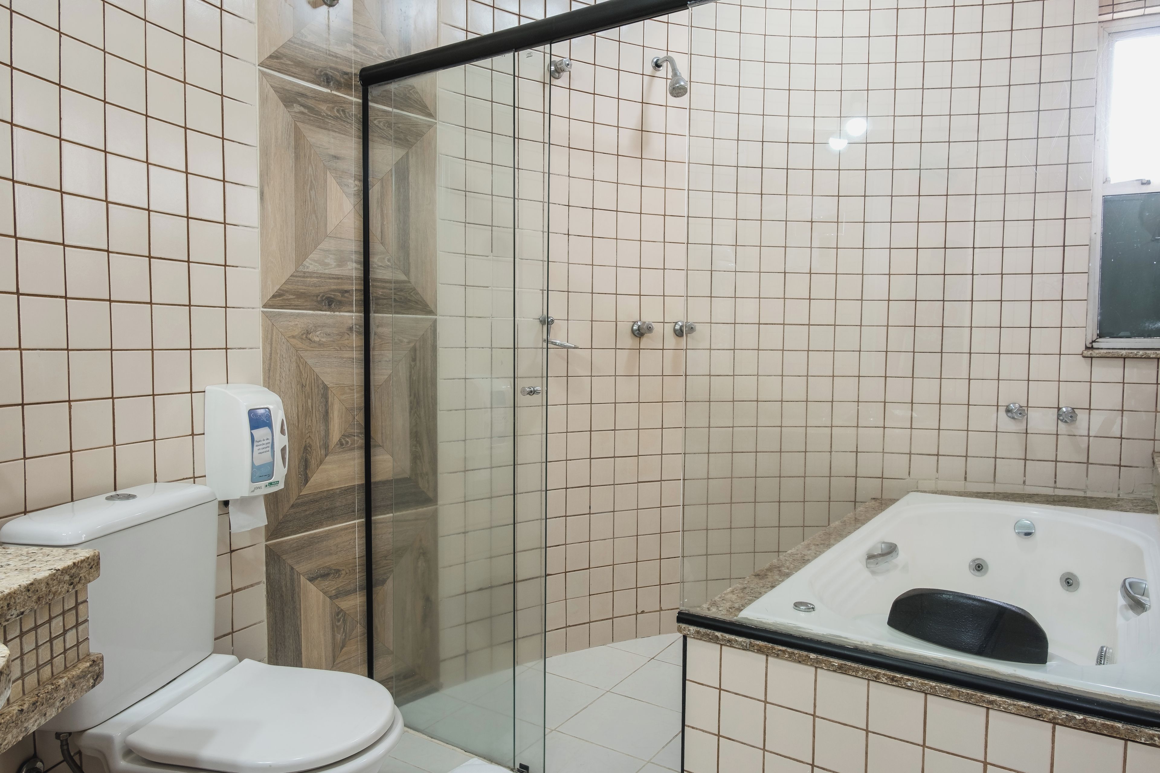 A bathroom with a glass-enclosed shower, a toilet, and a bathtub.