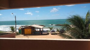 A view of a beach with a small wooden structure and parked cars. - Atlântico Hotel (Maceió)