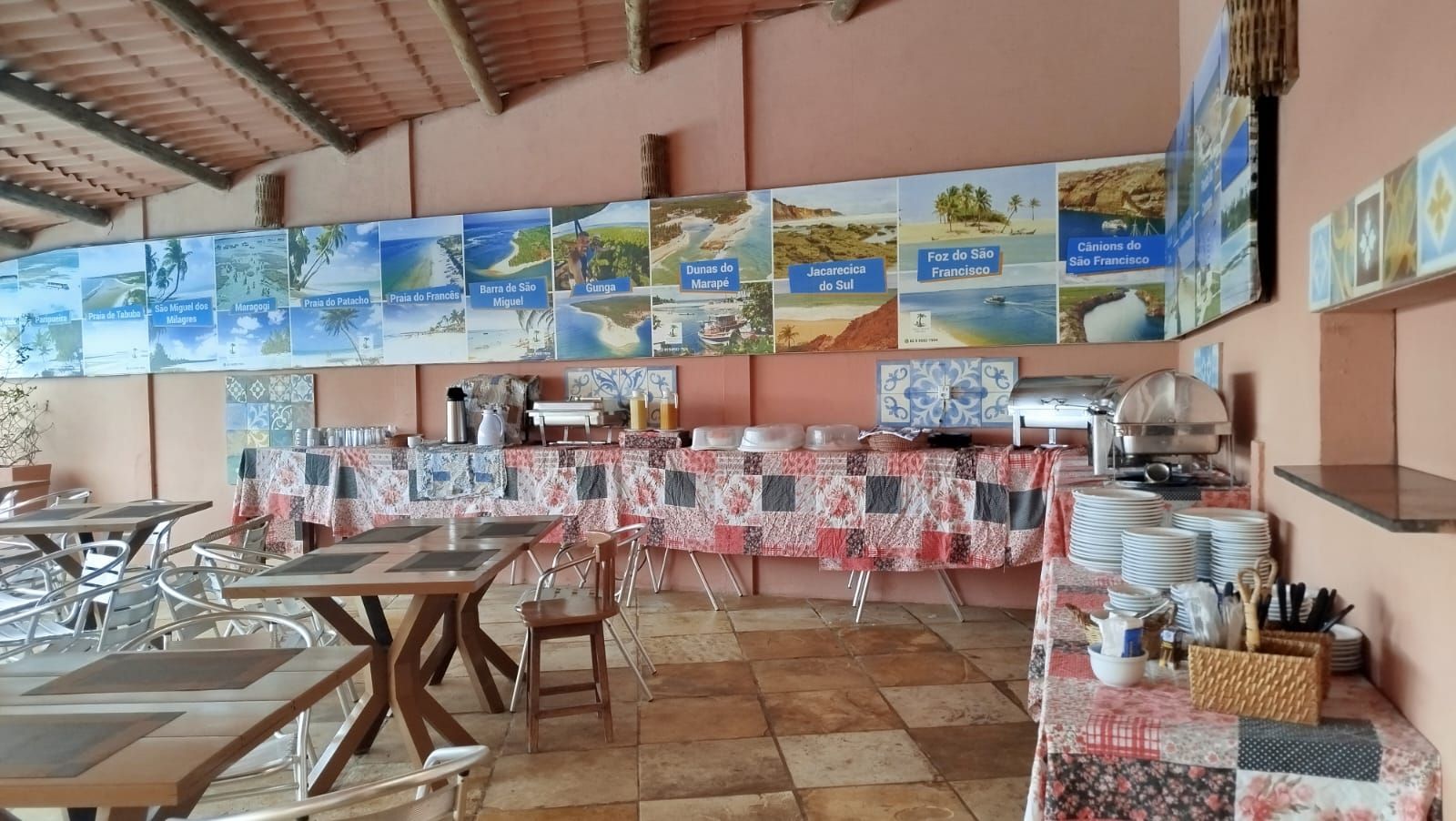 A restaurant with multiple tables and chairs, a buffet setup, and a wall decorated with regional maps.