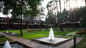 A courtyard with multiple water features, a well-maintained lawn, and a row of buildings with balconies. - Grand Admiral Resort & SPA (Irpin)