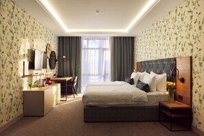 A hotel room with a bed, desk, and seating area. - Grand Admiral Resort & SPA (Irpin)