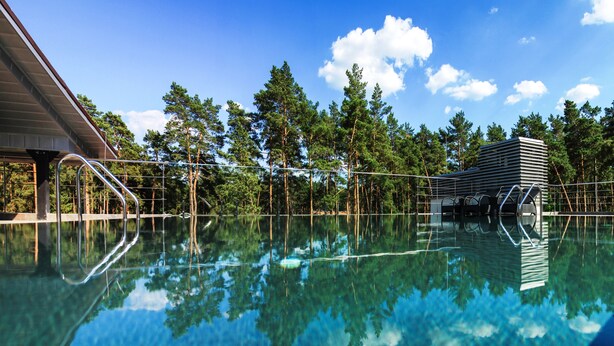 A clear swimming pool with a metal ladder and a metal fence. - Grand Admiral Resort & SPA (Irpin)