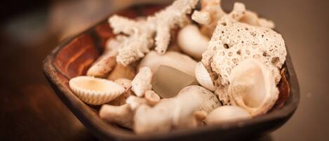 A bowl containing various types of mushrooms and a piece of tofu.