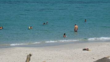 A beach with people swimming and relaxing.