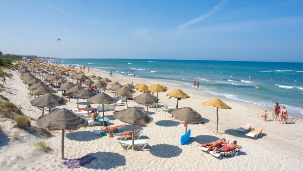A beach with rows of sun loungers and thatched umbrellas. - Houria House Sable d'Or (Mahdia)
