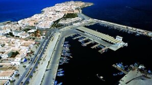 An aerial view of a coastal town with a marina, roads, and buildings. - Houria House Sable d'Or (Mahdia)